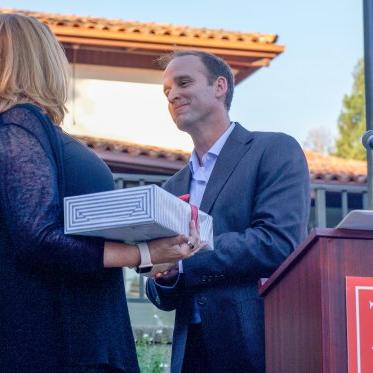 Corey congratulates a faculty member