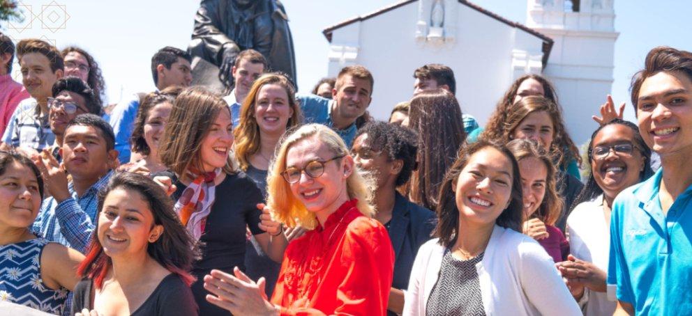 Students standing in front of the chapel smiling