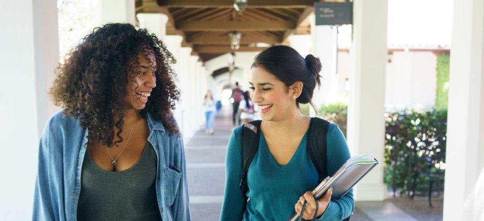 Two students walking with backpacks on