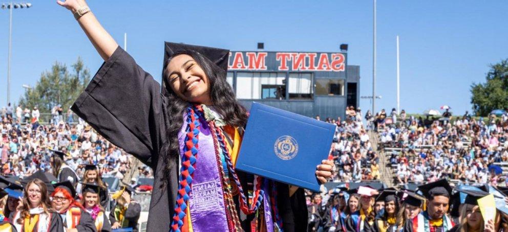 student hoding diploma smiling