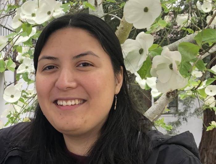 magaly is smiling and standing next to a dogwood tree