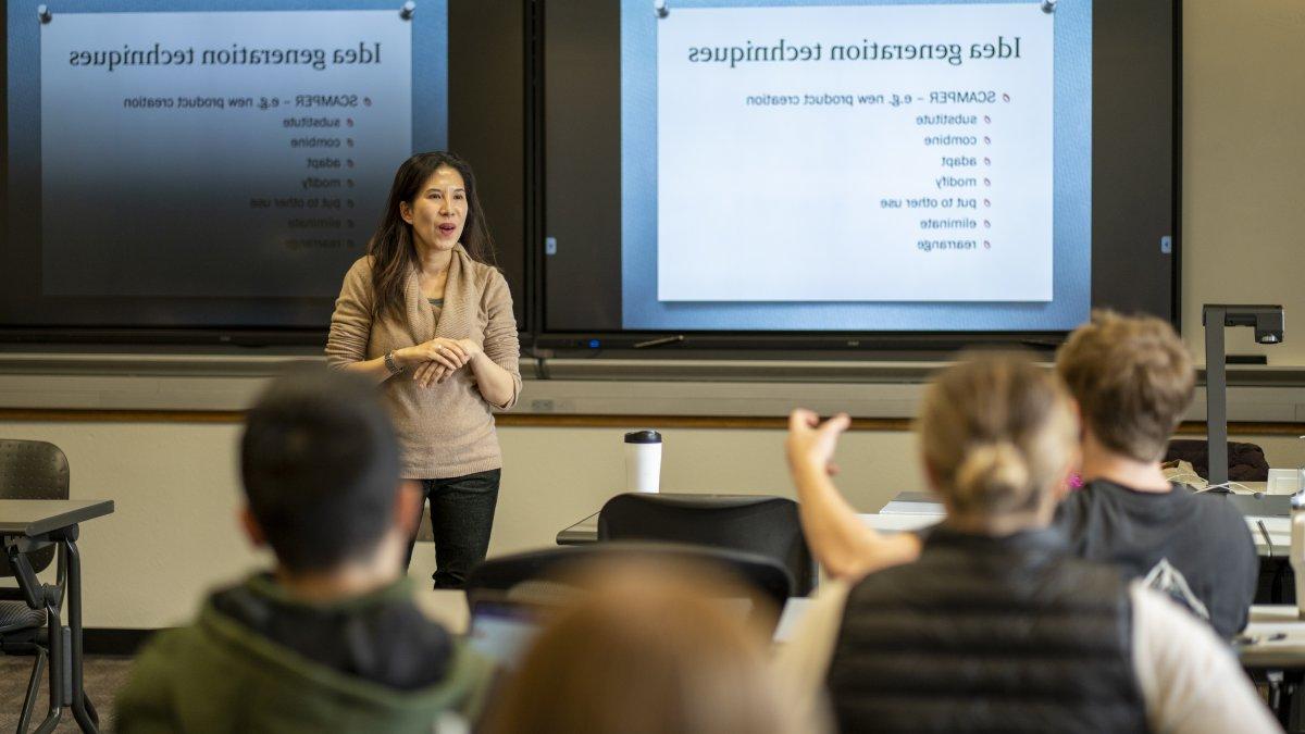 Professor Nancy Lam speaking to her JAN 101 - Turning On the Light Bulb: Illuminating, Unleashing and Managing Creativity course. On the screen behind her is a slide titled "Idea Generation Techniques"