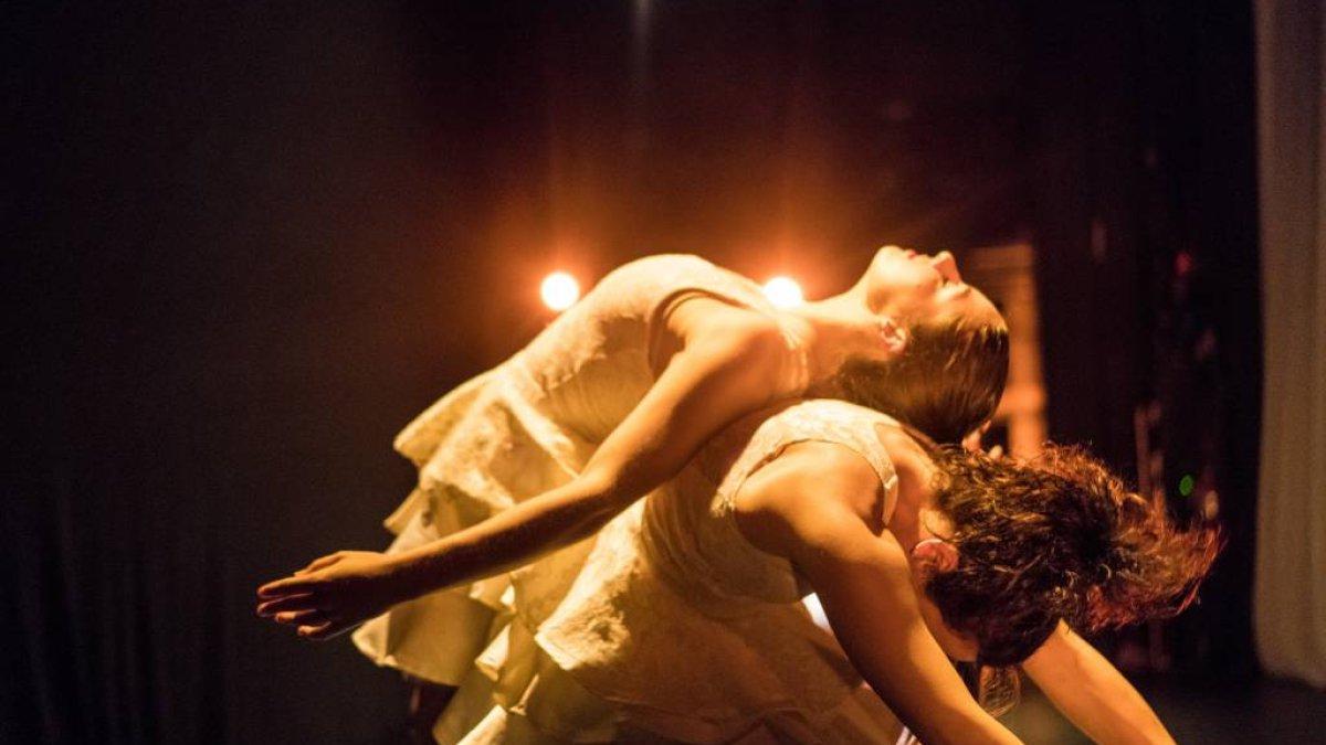 Two female dancers back-to-back on stage